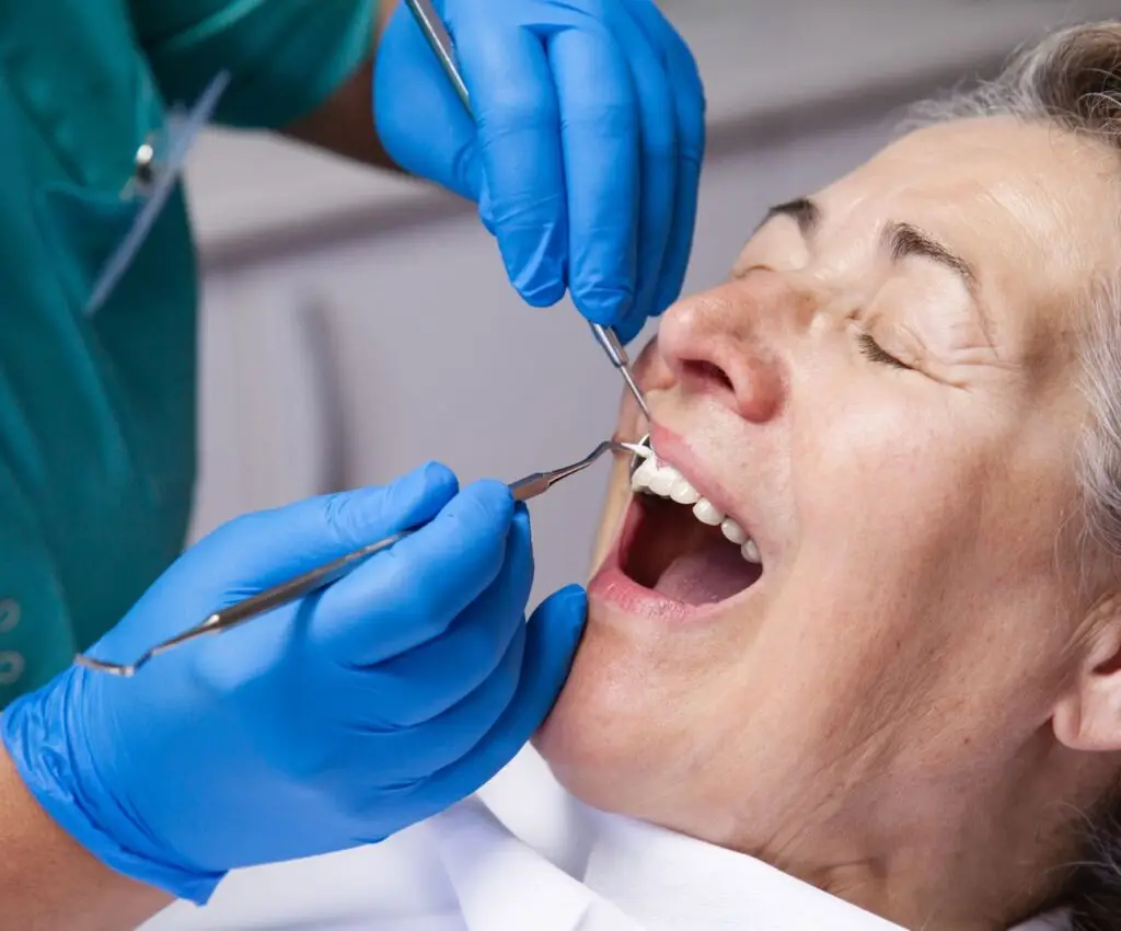 Mujer daulta mayor recibe tratamiento odontologico para reponer mediente protesis dentales los dientes perdidos