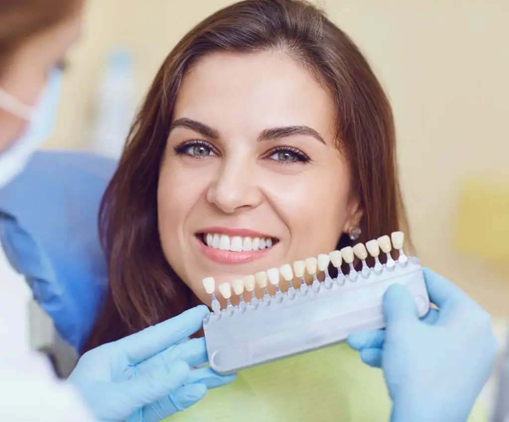 Mujer sonrie delante de su odontologo para tomar el registro de color de sus dientes para un blanqueamiento dental